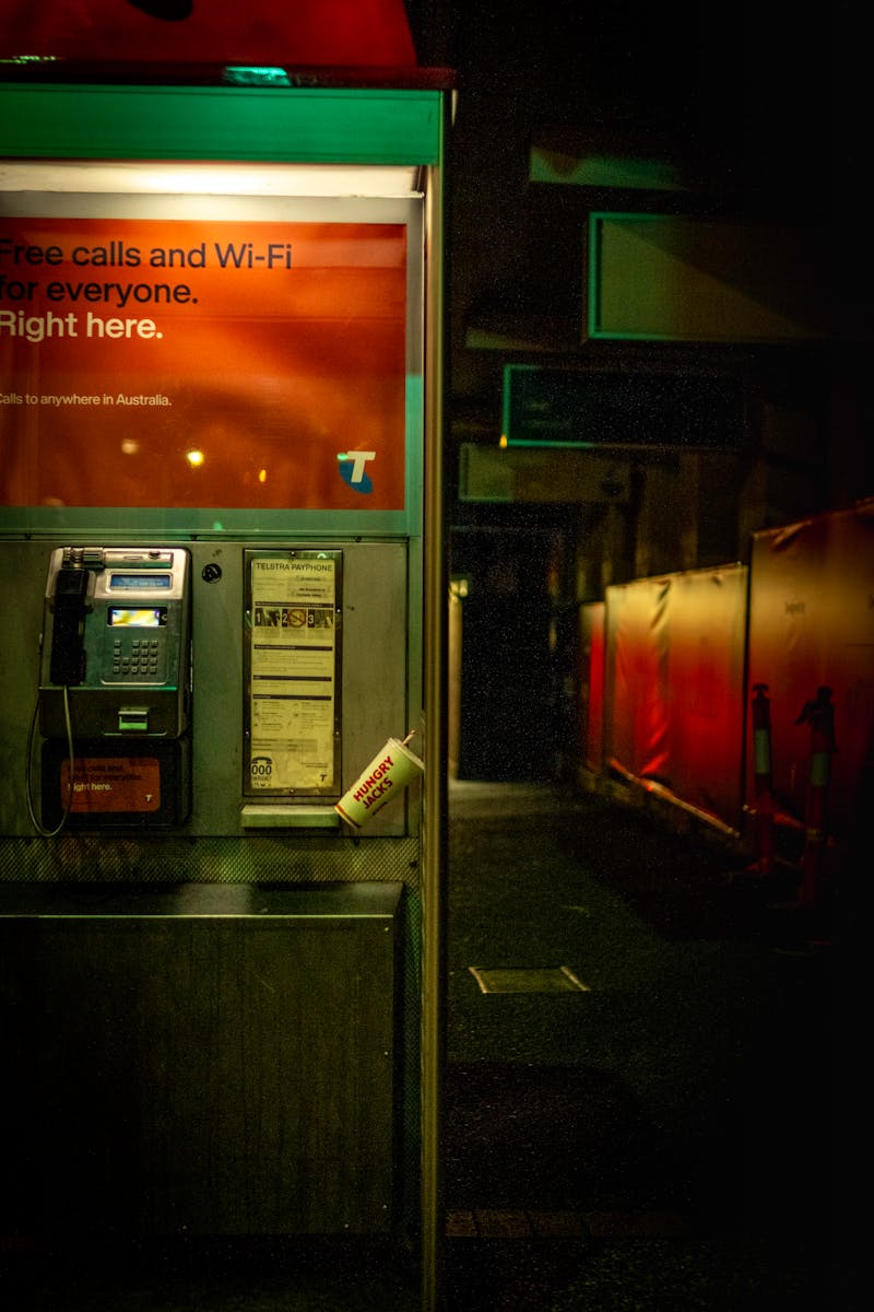 Night view of an illuminated phone booth in Brisbane City, Australia, showcasing urban ambiance.